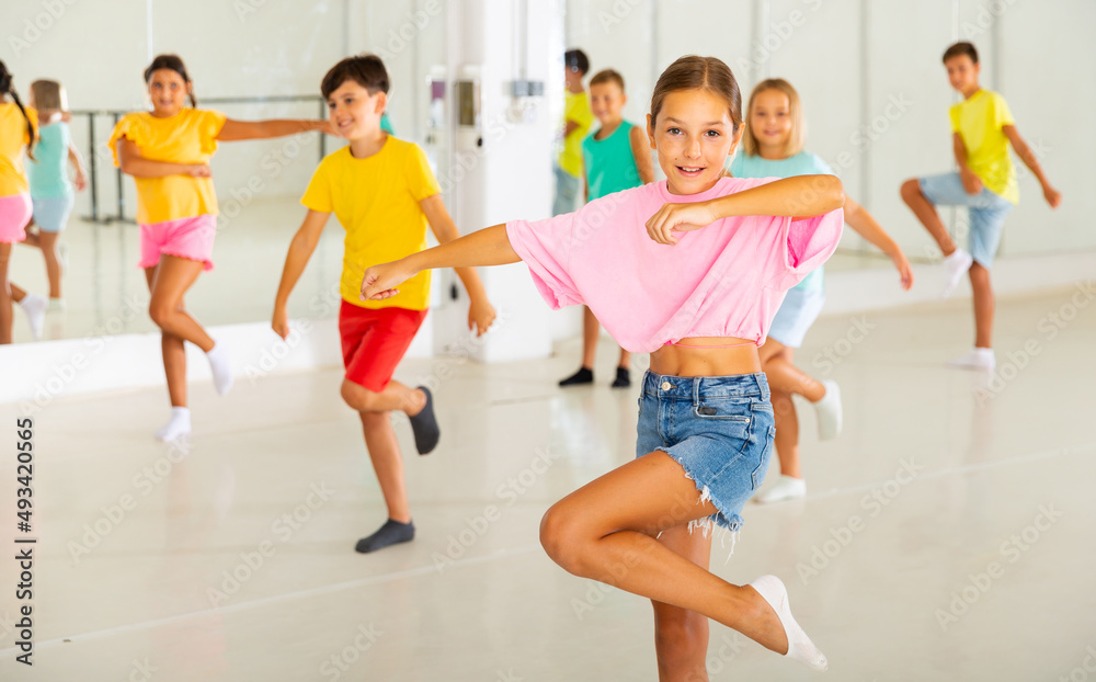 Group of kids training dance moves together in studio.