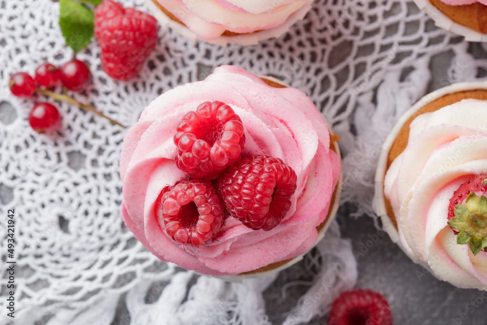 Pink cupcakes with cream and fresh berries Pink cupcakes with cream and fresh berries