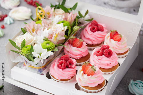 Pink cupcakes with cream and fresh berries