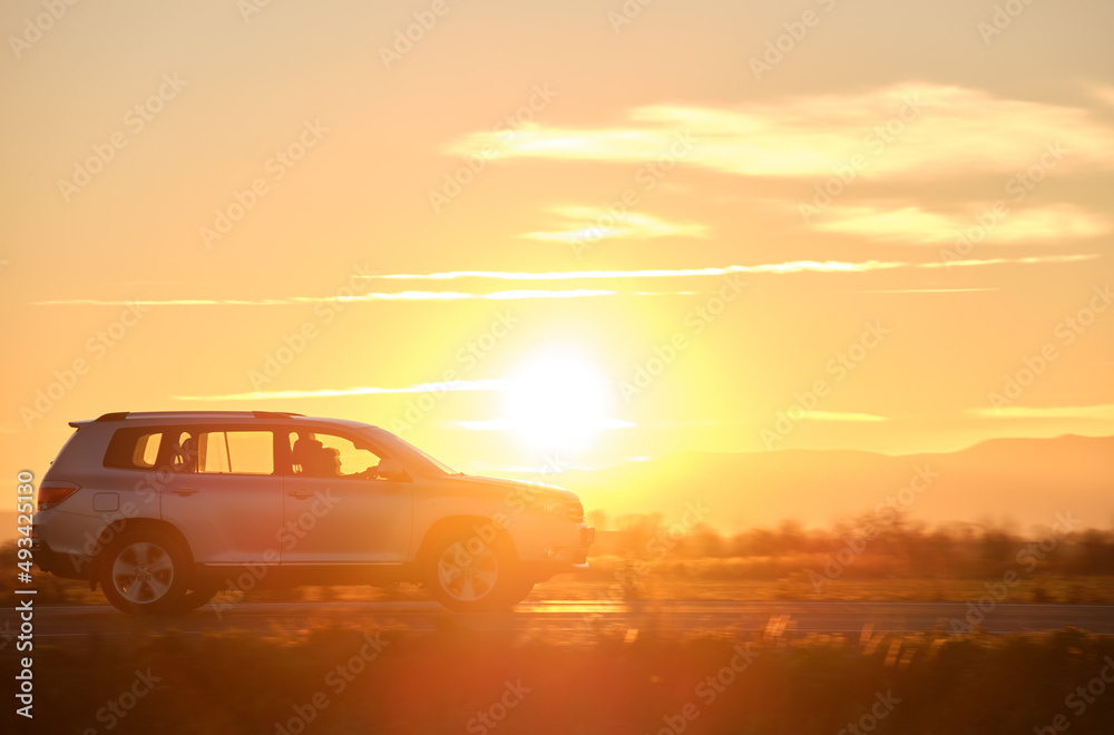 SUV car driving fast on intercity road at sunset. Highway traffic in evening