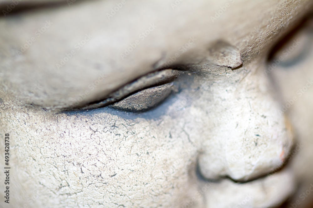 Obraz premium Close up detail of an old stone statue face