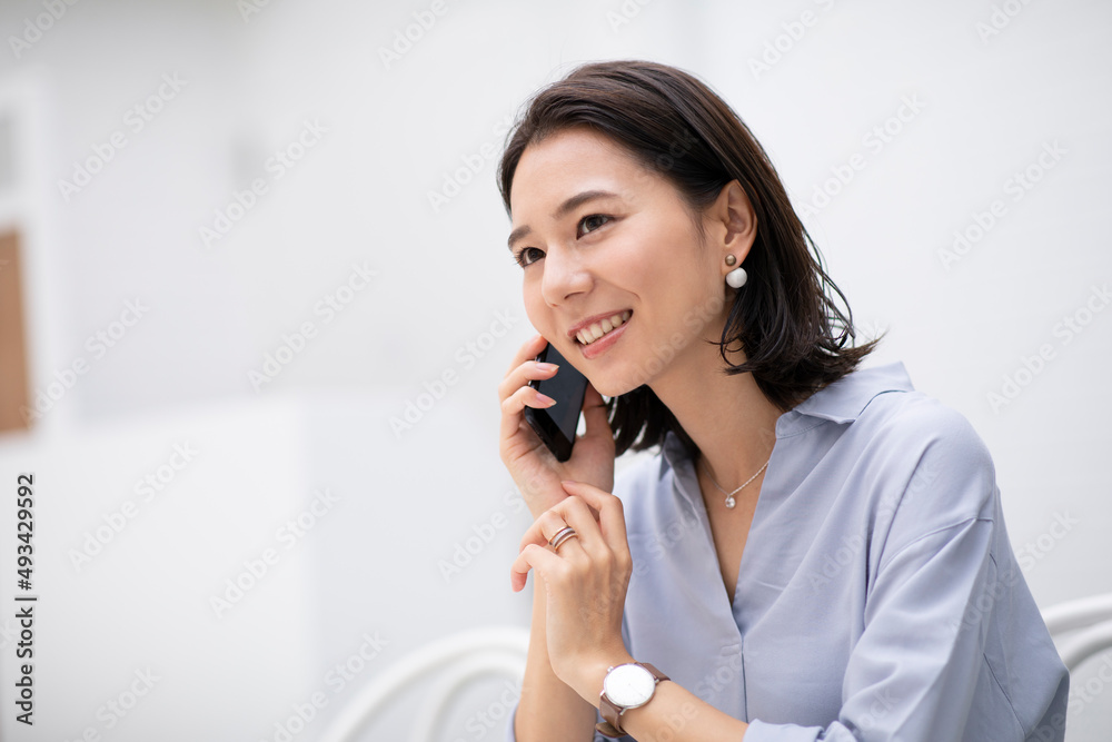 屋内で電話をする女性