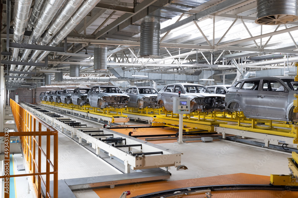 Car bodies are on assembly line. Factory for production of cars. Modern automotive industry Car bodies are on assembly line. Factory for production of cars. Modern automotive industry
