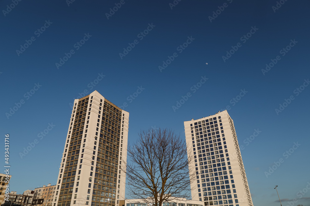 The urban landscape of large city. Exteriors of typical modern apartment buildings against a blue sky with clouds. 