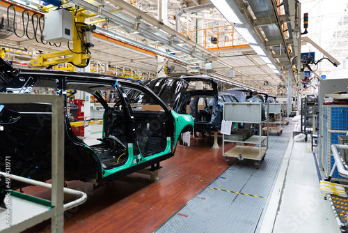 Photo of automobile production line. Welding car body. Modern car assembly plant. Auto industry. Interior of a high-tech factory