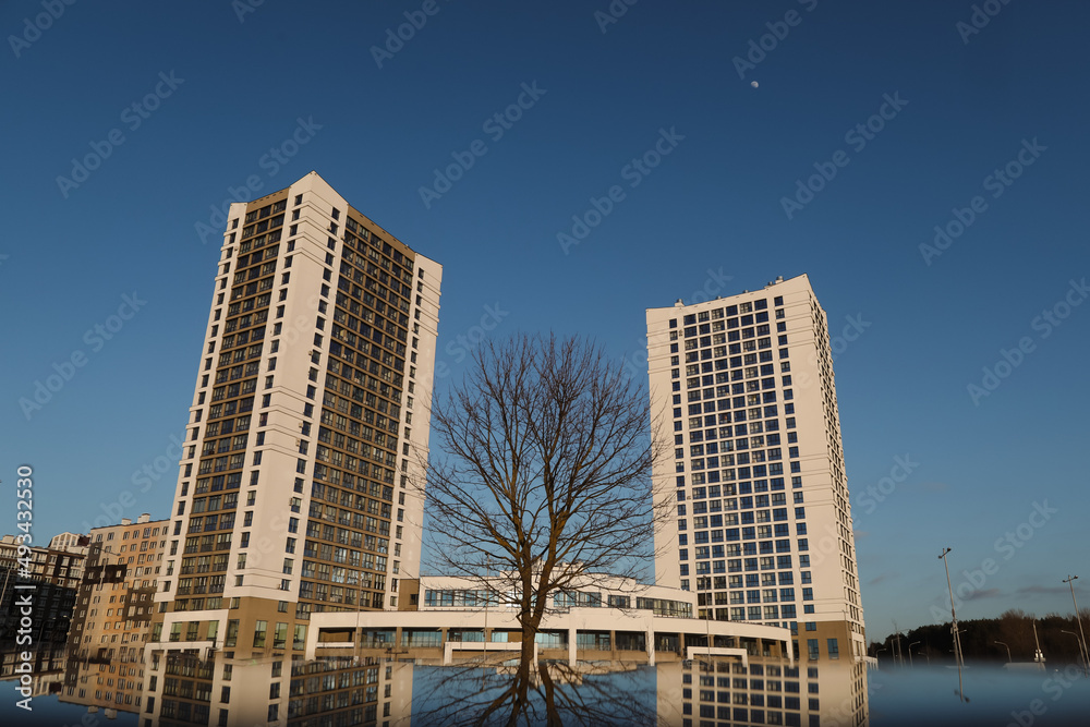 The urban landscape of large city. Exteriors of typical modern apartment buildings against a blue sky with clouds. The urban landscape of large city. Exteriors of typical modern apartment buildings against a blue sky with clouds.