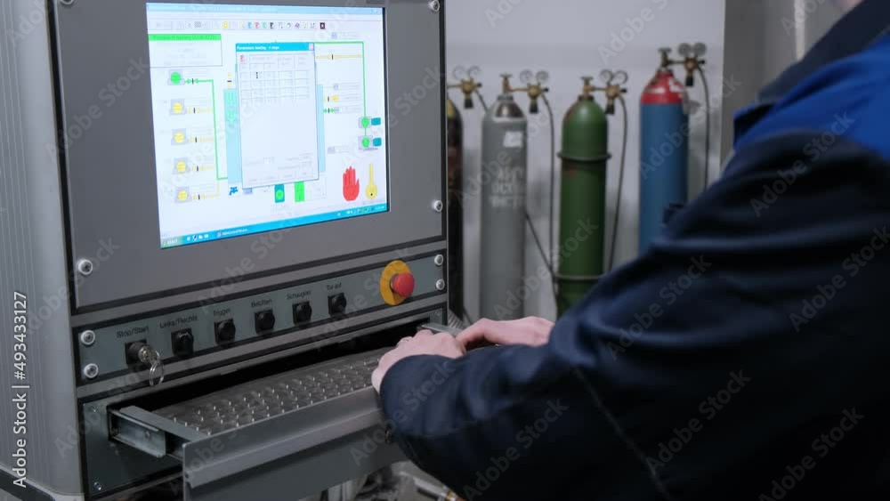 The hand presses the control buttons of the machine at the factory. The control panel of the CNC machine. Close-up. The hand presses the control buttons of the machine at the factory. The control panel of the CNC machine. Close-up.