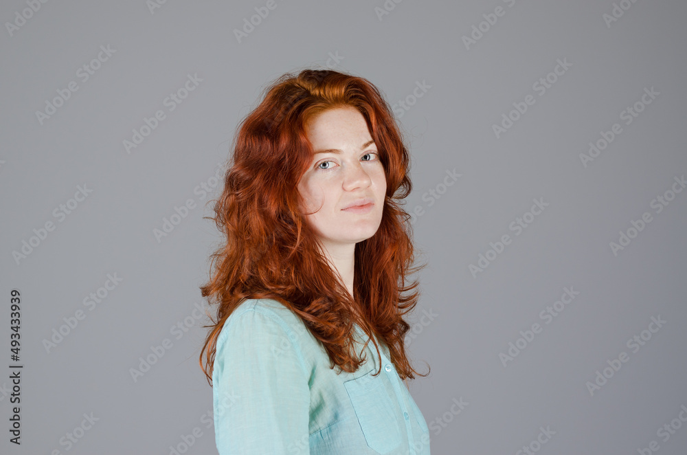 Business portrait of beautiful young woman with red curly hair and blue eyes against colorful background. Lifestyle. Business portrait of beautiful young woman with red curly hair and blue eyes against colorful background. Lifestyle.