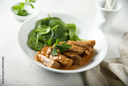 Homemade beef ragout with fresh spinach