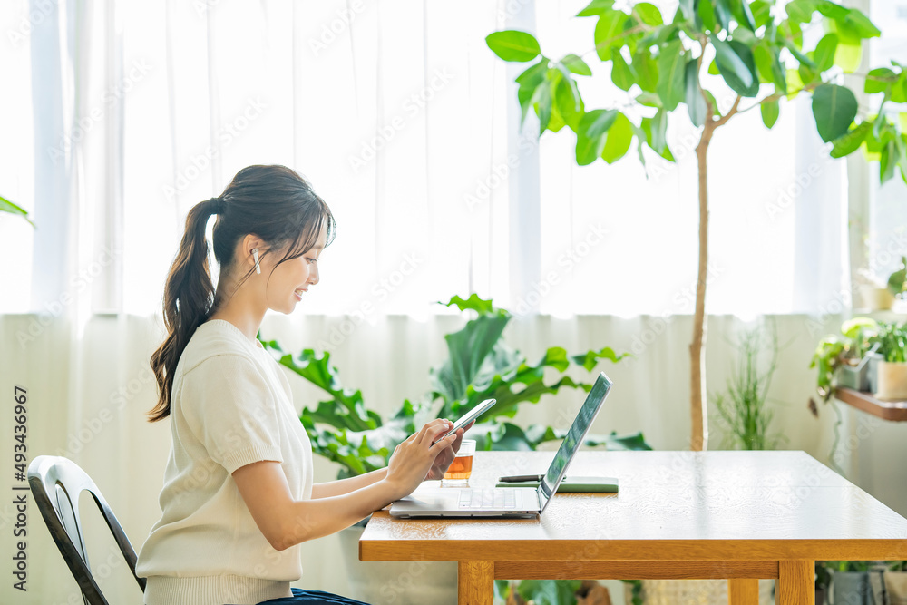 カジュアルな空間でノートPCで仕事をする女性