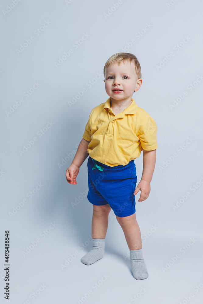 Little boy 3 years old in a yellow T-shirt and blue shorts, a boy in a sports uniform. Little boy 3 years old in a yellow T-shirt and blue shorts, a boy in a sports uniform.