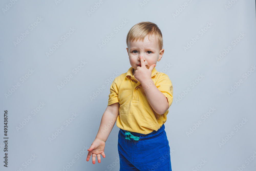 Little boy 3 years old in a yellow T-shirt and blue shorts, a boy in a sports uniform.