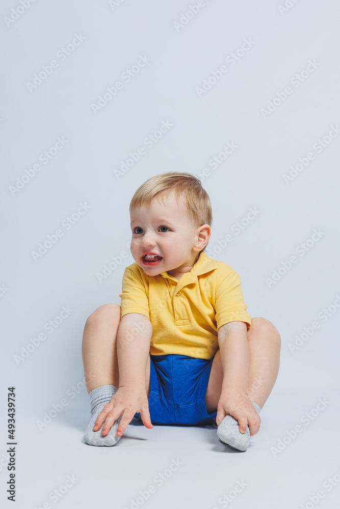 Little boy 3 years old in a yellow T-shirt and blue shorts, a boy in a sports uniform. Little boy 3 years old in a yellow T-shirt and blue shorts, a boy in a sports uniform.