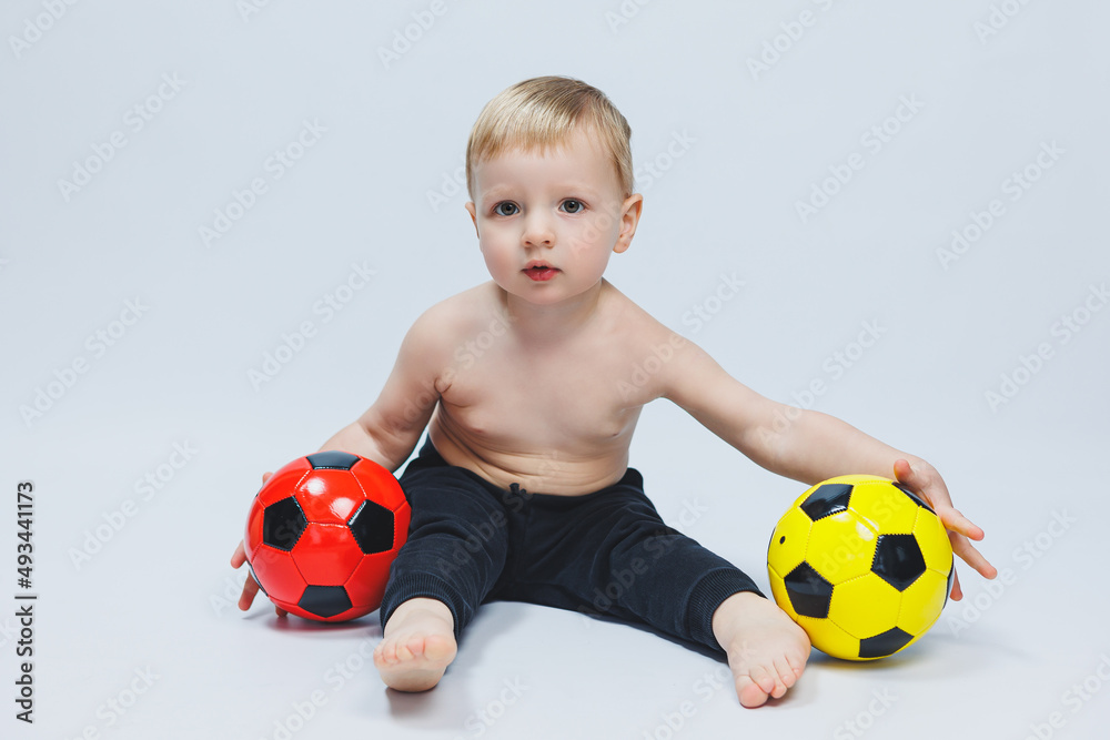 Fan boy holding a soccer ball in his hands, isolated on a white background. newbie in football, sport for kids. Little athlete. Fan boy holding a soccer ball in his hands, isolated on a white background. newbie in football, sport for kids. Little athlete.