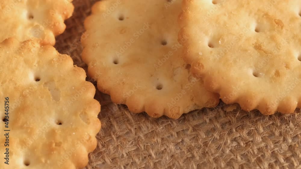 Circle crackers with salt. Close up. Rotating cracker cookies background. Tasty food. Beautiful round crackers on canvas Circle crackers with salt. Close up. Rotating cracker cookies background. Tasty food. Beautiful round crackers on canvas