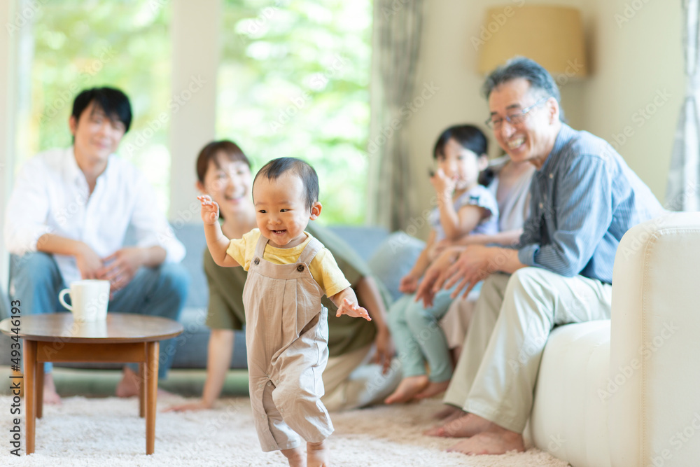 リビングで歩く子供を見守る三世代ファミリー リビングで歩く子供を見守る三世代ファミリー