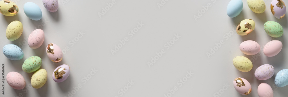 Happy Easter banner with pastel decorative colourful eggs on neutral gray background. View from above. Flat lay. Greeting card. Copy space. Happy Easter banner with pastel decorative colourful eggs on neutral gray background. View from above. Flat lay. Greeting card. Copy space.