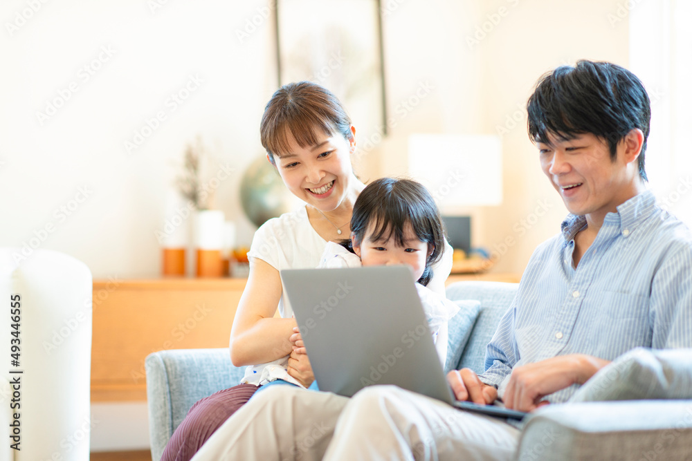 リビングでパソコンを見るファミリー