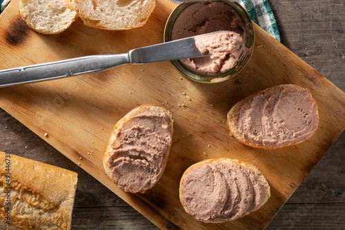Toasted bread with pork liver pate on wooden table.