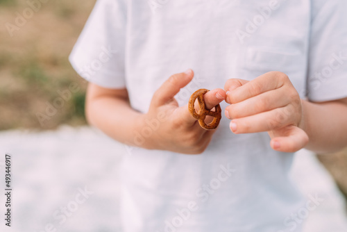 Salzbrezel in Hand eines Kindes horizontal