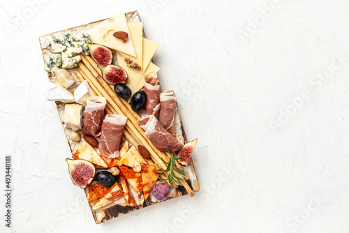 Cheese platter. Assorted cheese, wine ham, fruit, bread sticks, nuts. banner, menu, recipe place for text, top view