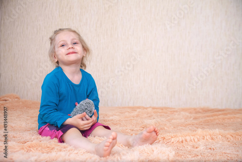 Little three-year-old girl with   toy  on blanket
