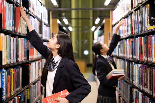 図書室で本を手に取る高校生 photo