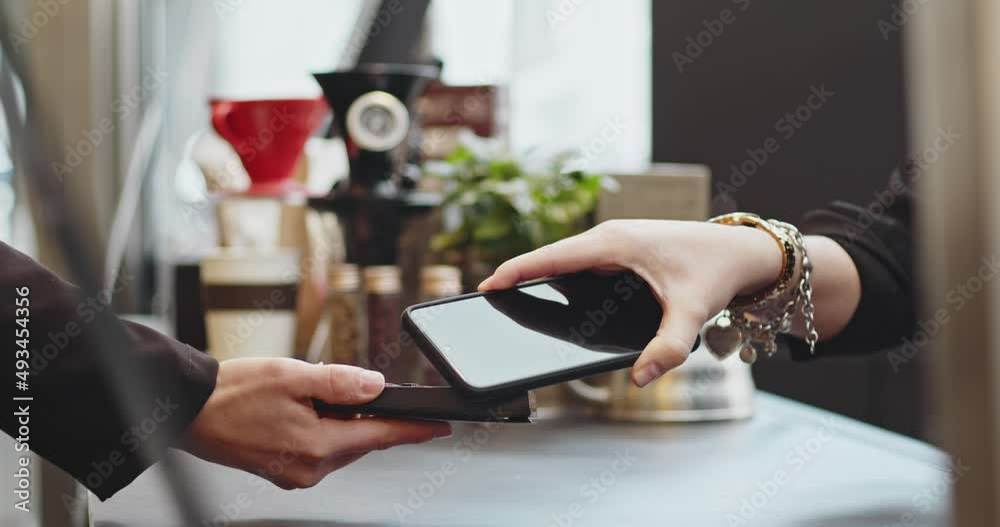 Close-up woman paying using NFC technology with phone contactless payment with student girl, business woman.Pay by phone on electronic payment machine or card reader. E-money at cashless wallet