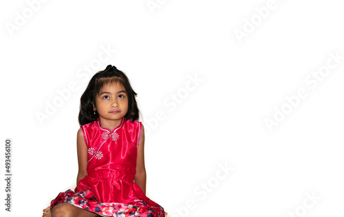 Adorable asian little girl sitting down on the white background looking up