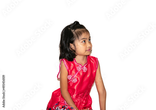 Smiling little girl sitting down on floor looking up, Isolated on white