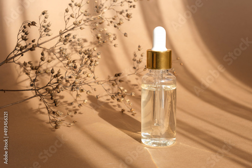 Natural oil cosmetics on neutral background. Dropper glass Bottle Mock-Up. Oily cosmetic pipette. Face and body treatment. Spa concept. Mineral organic oil. Flat lay with beauty products. Blank bottle