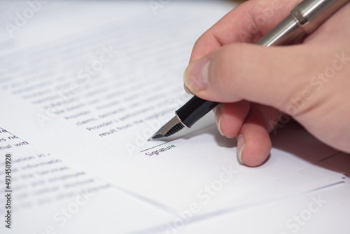 Close up of hand writing on contract 