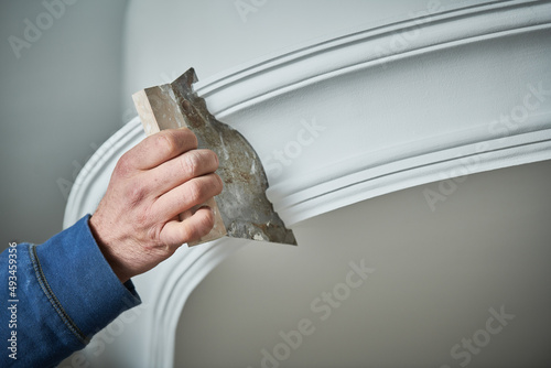 Leinwand Poster Painting and plasterwork. worker hand with spatula making molding