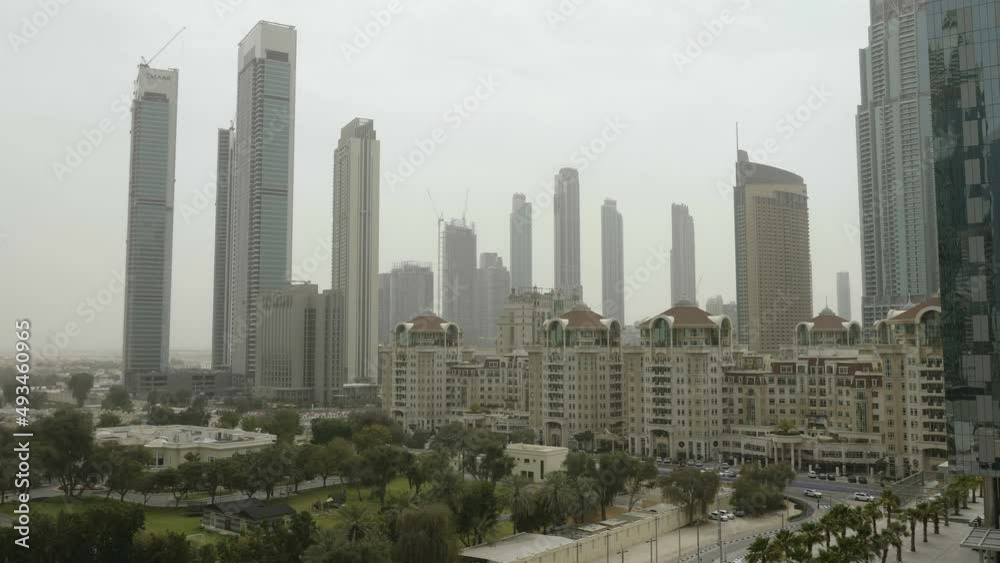 The facade view of the tall skyscrapers in Dubai on a hot sunny day in the city in UAE The facade view of the tall skyscrapers in Dubai on a hot sunny day in the city in UAE