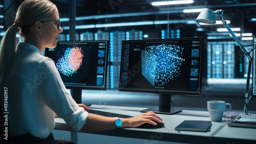 European Female Specialist Works on a Computer with Neural Network Visualisation in a Monitoring Center with Global Map Tracking on a Big Digital Screen. Big Data concept