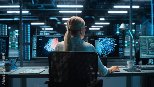 Futuristic Concept: Female Computer Engineer Looking on the Two Displays while Working on the Computer. Screen Shows Interactive Neural Network, Artificial Intelligence Project, User Interface
