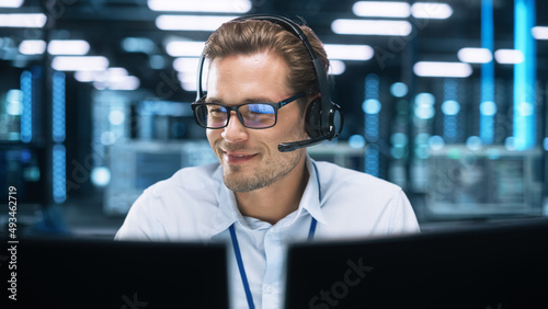 Concentrated Male Customer Support Agent Receptionist wear Headset Consult Online Client Looking at Computer Screen, Helpline Operator Secretary Make Conference Video Call photo