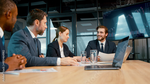 Smiling business analysts discussing a project at a meeting