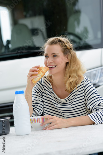 woman taking breakfast outside her camper