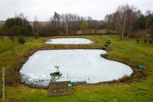 forging a hole in the ice to sea in the lake