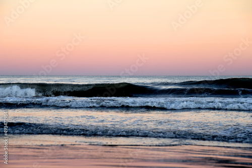 Coast with waves in sea on sunset. Waves in sea during storm and wind. Wave from the sea goes on land to the beach. Splashing Waves in ocean. Wave at Rising Storm near Seashore or Coastline. Seaside.