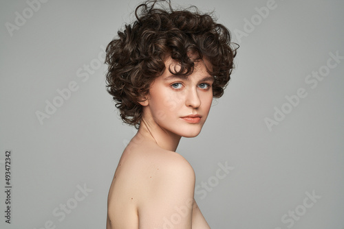 Portrait of unusual woman with curls isolated on gray background