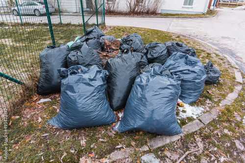 Black garbage bags lie on a green lawn (1211)