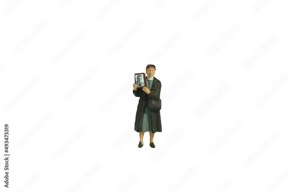 Miniature people toy figure photography. A woman holding photo frame, searching missing person because of war conflict Miniature people toy figure photography. A woman holding photo frame, searching missing person because of war conflict