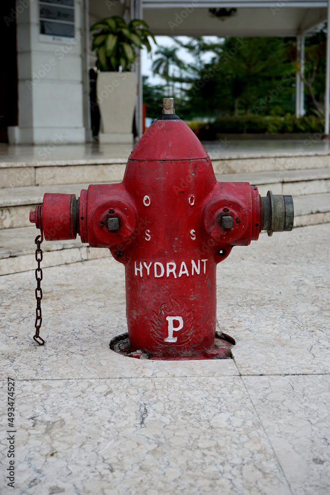 The striking red hydrant is located in the public area of the Surabaya city square The striking red hydrant is located in the public area of the Surabaya city square