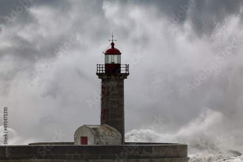 Waves splash and spray over lighthouse