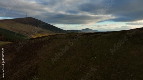 Mount Leinster, Carlow, Ireland, March 2022. Drone pushes southeast above hillwalkers at Rathnageeragh towards the summit with the Blackstairs and Kiltealy in the distance. photo
