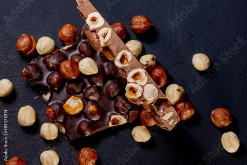 Top view in section on a bar of dark chocolate with hazelnuts