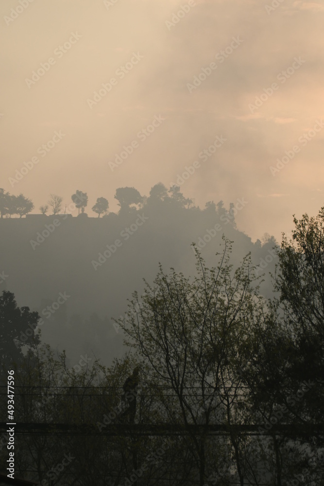 Fototapeta premium Vieille personne qui traverse un pont dans les montagnes au népal