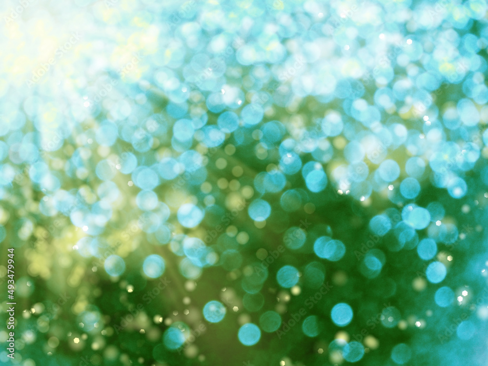 spring abstract green blurs background with sunny beams shiny bokeh